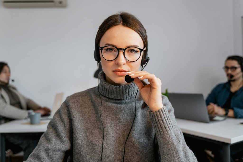 Photo by MART  PRODUCTION: https://www.pexels.com/photo/photo-of-a-woman-with-black-framed-eyeglasses-touching-a-microphone-7709207/