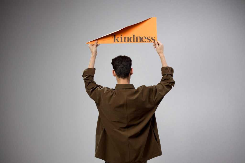 Photo by Ron Lach : https://www.pexels.com/photo/back-view-of-man-in-shirt-standing-and-holding-kindness-text-9168806/